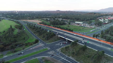 hyperlapse aerial perspective of traffic building at traffic intersection with moving carriageway on arterial above.
