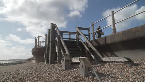 wooden stairs going down onto pebble beach in hastings, england