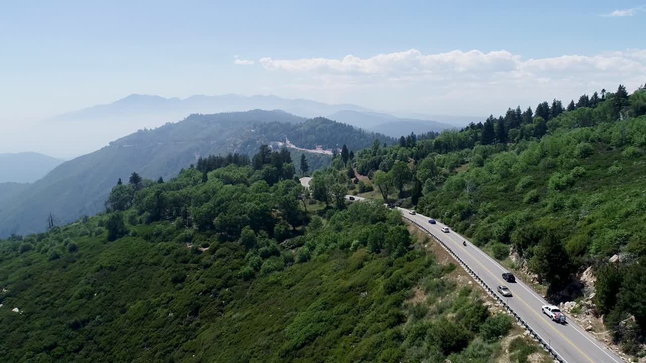 un drone de seguimiento de 4k disparó a los coches que conducen en una carretera encontrada en lo alto de un paso de montaña cerca del bosque nacional de angeles y mt.
