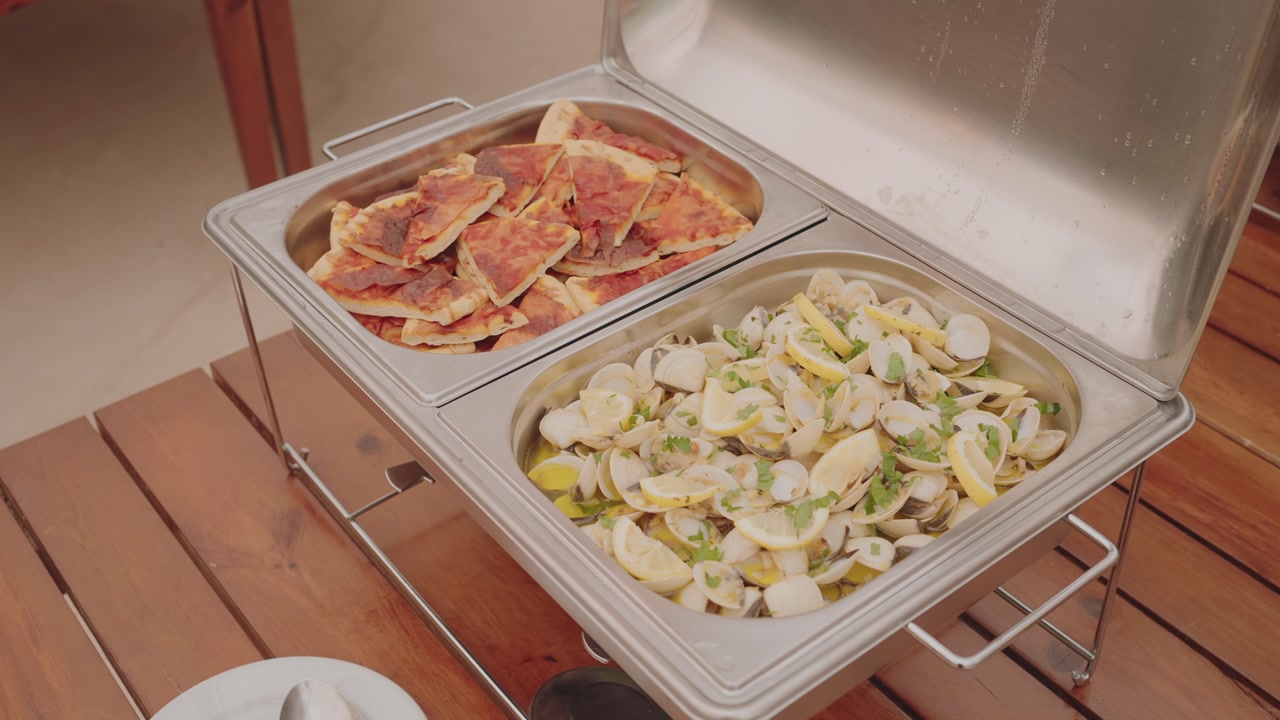 Buffet trays serving pizza slices and clams with lemon