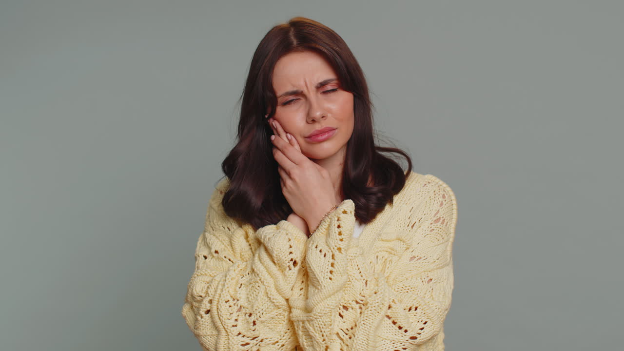 mujer tocando la mejilla que sufre de dolor de muelas, caries o gingivitis esperando una cita con el dentista