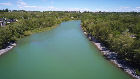 Drone-flying-over-a-beautiful-river-on-a-sunny-day-in-the-city