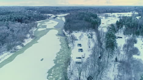 nordic winter landscape, countryside forested area near forzen river, aerial orbiting