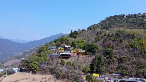 edificios coloridos ubicados en una ladera boscosa, cielo azul, vista aérea
