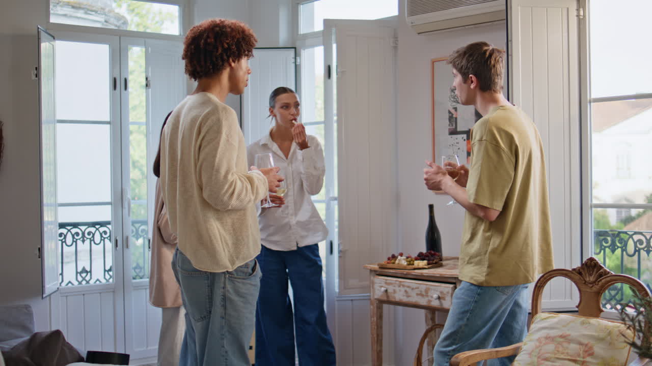 Carefree friends hanging out drinking alcohol at party. Students eating snacks