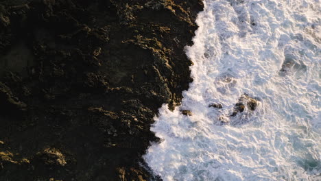 Waves-crashing-in-a-high-angle-view-from-a-drone-at-Sandy-Beach-in-Oahu,-Hawaii