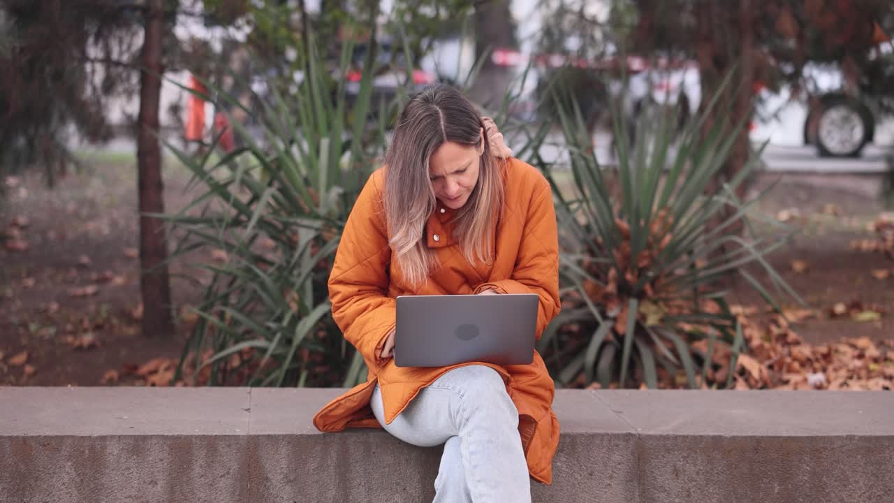 Woman working on laptop in the park