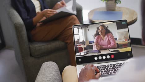 African-american-man-using-laptop-for-video-call,-with-business-colleague-on-screen