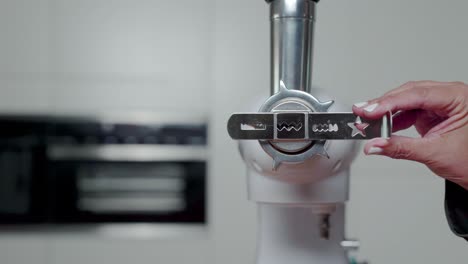 hands putting new shape in nozzle of food processor, static closeup