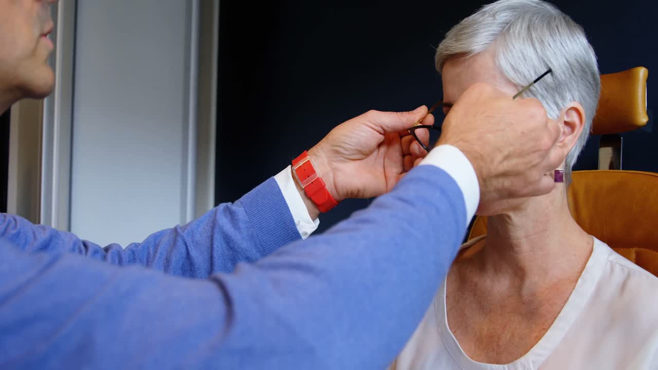 환자의 눈에 안경을 조정하는 안경학자 4k