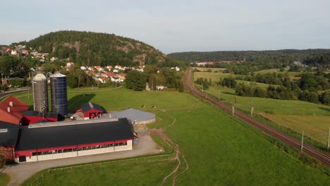 Tren-Eléctrico-De-Dos-Pisos-Sj-X40-Que-Pasa-Por-Una-Granja-En-Suecia,-Vista-Aérea