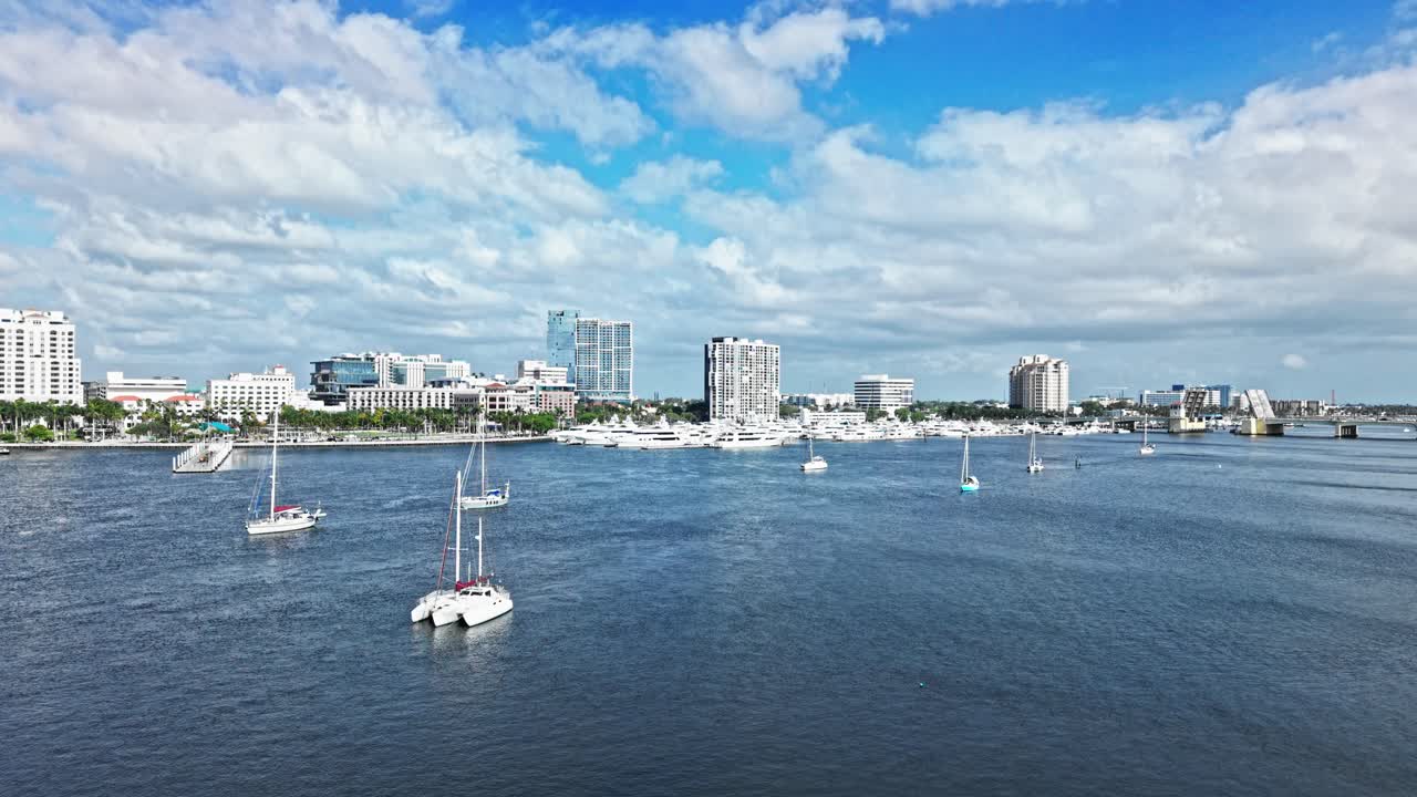 Aerial: West Palm Beach marina, harbor and cityscape with white yachts during the day in Florida, USA, dolly in drone shot