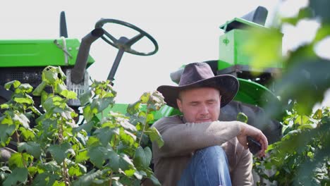 tired farmer resting sitting by a tractor tired farmer resting sitting by a tractor depression in a country man agriculture concept