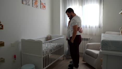 young pregnant couple checking the room for the future baby