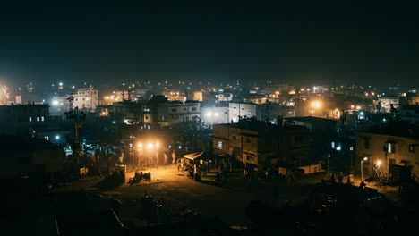 a vibrant night scene of a bustling cityscape lit by street lights and activity in a commercial area, capturing life after dark with people gathering and illuminated buildings
