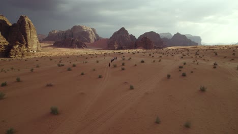 people trekking through arabian, middle east wadi rum desert, jordan, aerial drone view