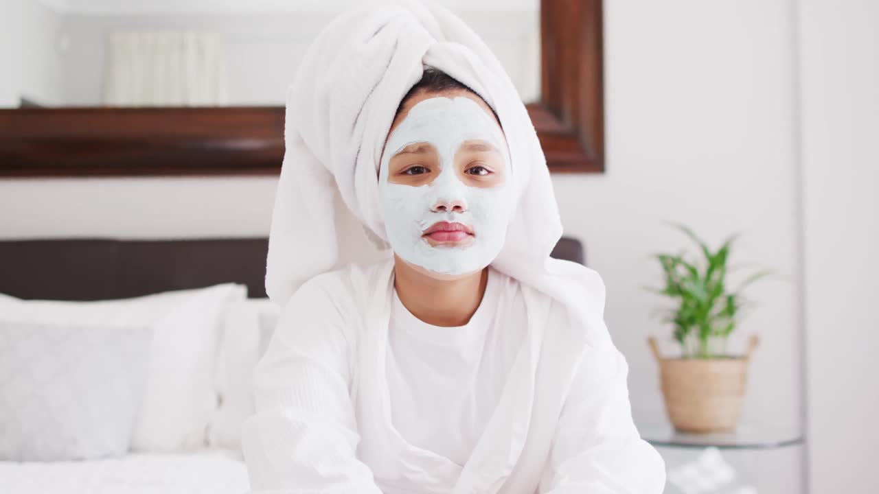 video de una chica asiática feliz en túnica con máscara hidratante divirtiéndose
