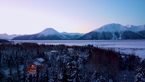 ariel reveal of snow covered alaskan town with turnagain arm and mountains