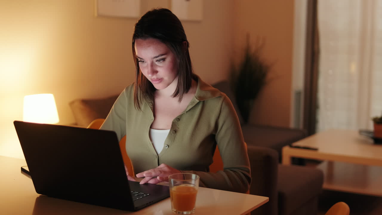 Donna che lavora da casa al computer portatile di notte