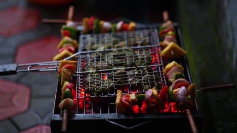 hand putting veggie skewers to grill