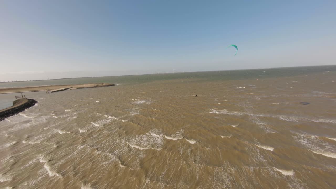 vuelo aéreo sobre kite surfer haciendo trucos aéreos de olas con viento fuerte