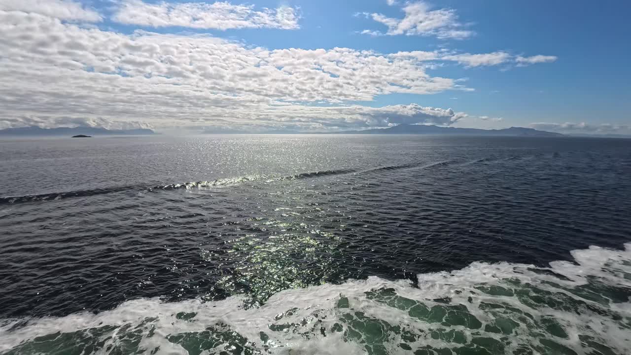 Malerischer Meerblick mit Sonnenreflexion und fernen Bergen
