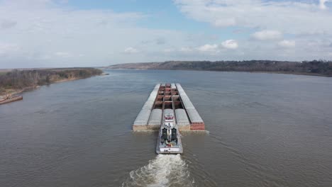 aerial close-up panning shot of a river barge transporting goods on the mississippi river