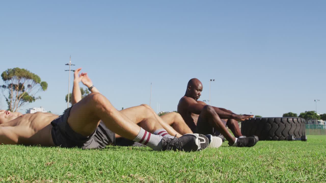 grupo diverso de tres hombres en forma haciendo ejercicio al aire libre, haciendo abdominales