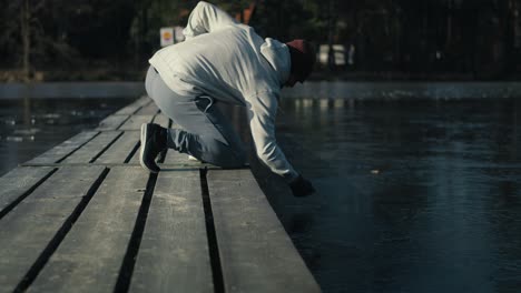 Caucasian-adult-man-checking-ice-for-swimming-in-frozen-lake.