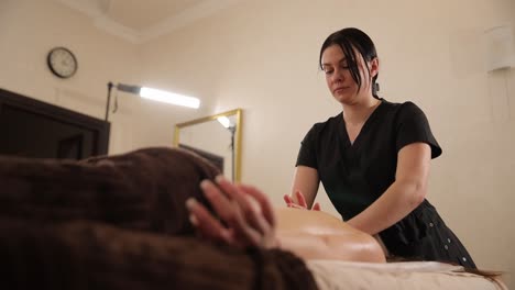 una mujer recibiendo un masaje de espalda en un spa.