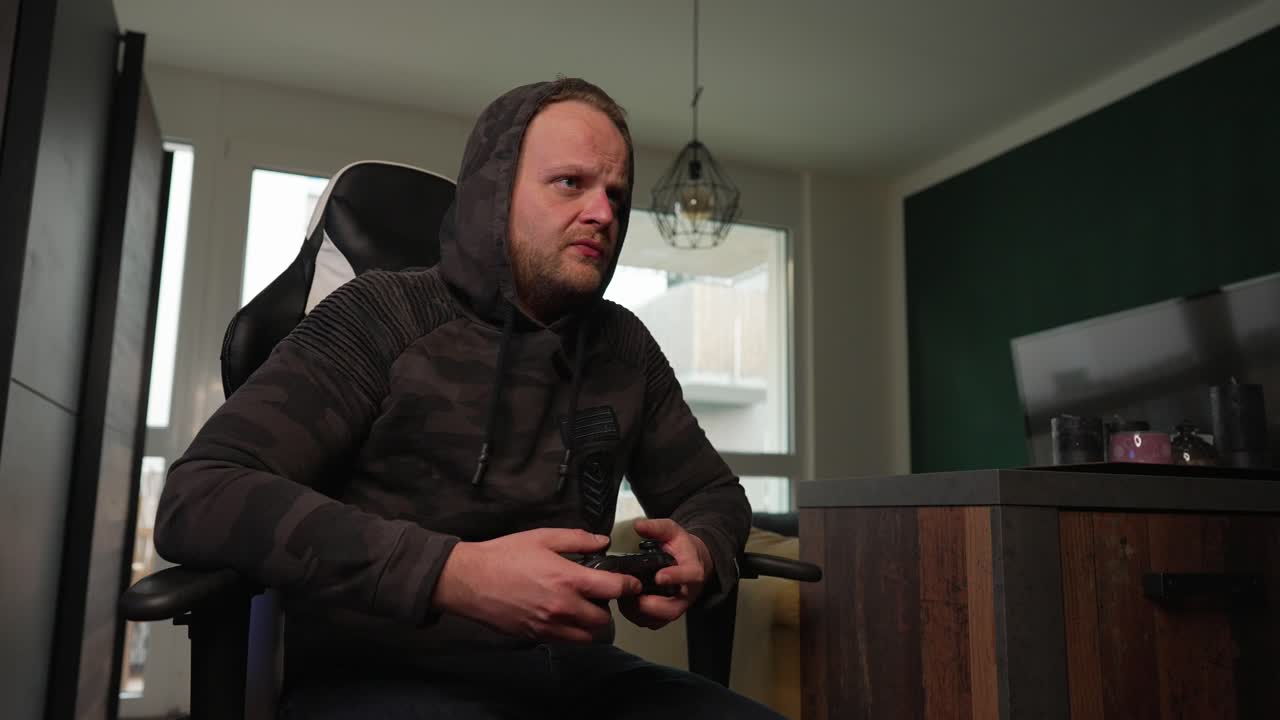 VIDEO GAMES - Man talks and moves while playing video game, medium shot