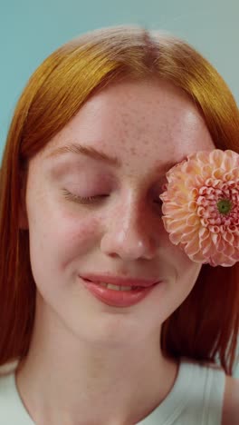 mujer con flor de dahlia en la cara