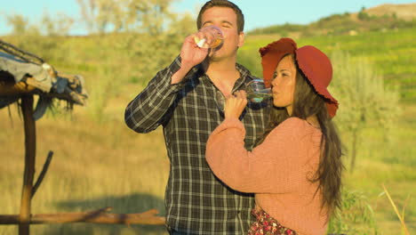 hermosa pareja caucásica degustando vino blanco de vasos