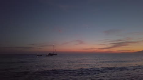 sailboats floating amidst calm sea during sunset on fabriquilla beach in almería, andalusia, spain