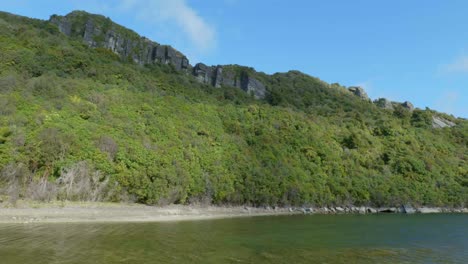 A-breathtaking-scene-unfolds-as-rugged-rock-formations-tower-above,-overlooking-a-tranquil-lake-below,-showcasing-the-harmonious-blend-of-nature's-artistry-and-serene-waters