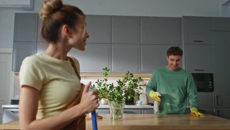 Cleaning couple communicating together kitchen closeup. Lovers domestic routine