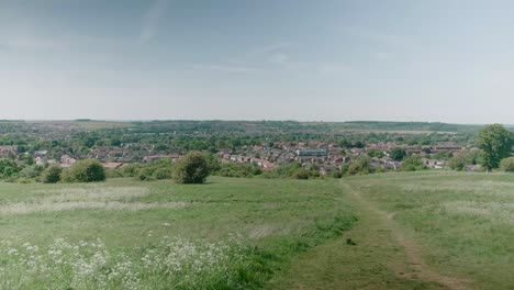 Ciudad-De-Grantham-Lincolnshire-Reino-Unido-Midlands-Orientales-Campos-De-Cultivo-Vista-En-La-Distancia-De-La-Ciudad-Día-De-Verano-Viento-Que-Sopla-Hierba-Y-árboles-Y-Cultivos-Alto-Punto-De-Vista-Casas-A-La-Vista-Y-La-Iglesia-De-St-Wulfram