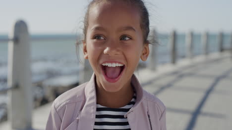 retrato pequeña niña de raza mixta niño riendo emocionado disfrutando de un hermoso día soleado en la playa costera