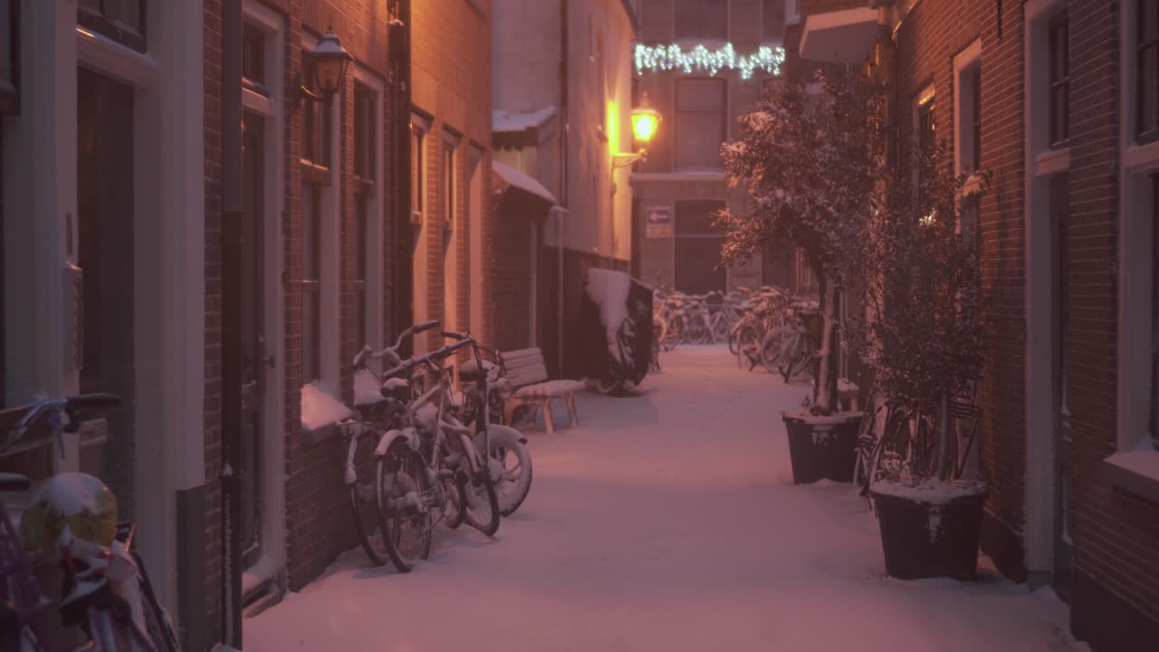 Walking through snowy Dutch city streets at night, winter alleyway view