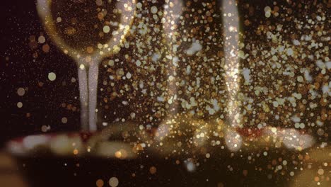 animation of gold dots over blurred glass of white wine and plate with olives
