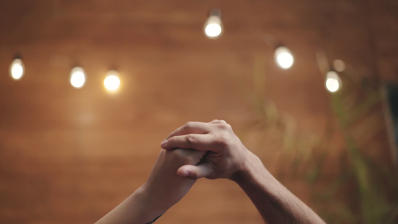 Romantic view of two hands playing with love together. Male and female hands isolated on blurred background. Love relationship concept.