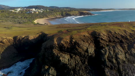 Tiro-De-Drone-Inclinado-Hacia-Arriba-De-La-Costa-Rocosa-En-Coffs-Harbour-Australia-Y-Emerald-Beach