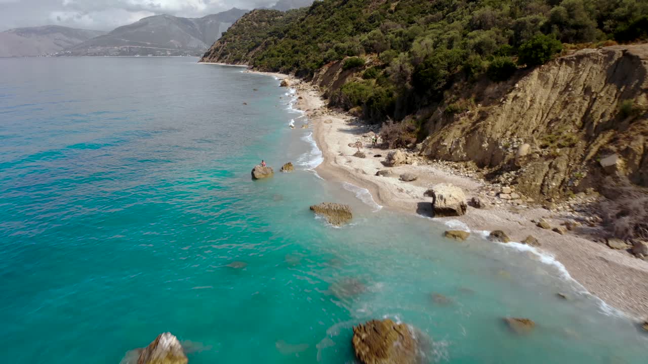 Rocky coastline and cliffs washed by crystal emerald sea water on a cloudy day in Ionian coastline