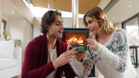 christmas time, couple exchanging gifts by cozy fireplace, enjoying festive holiday moment together