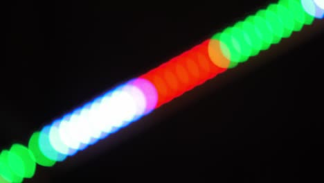 bokeh shot of defocused blurred christmas tree light that is blinking on black