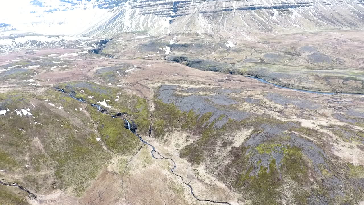 Ripresa con drone che si inclina verso l'alto sulle montagne innevate dell'Islanda