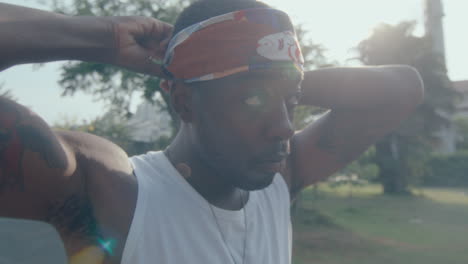 young african american basketball player putting on headband outdoor