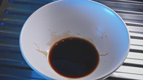 mixing soy sauce and honey in a white bowl use for cooking honey garlic chicken recipe