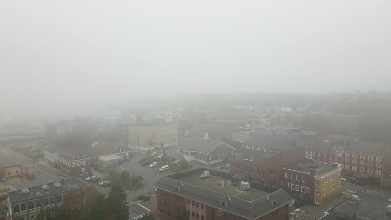 나무의 가을 색을 보여주는 목욕의 도시를 드러내기 위해 안개 상태에서 공중 드론 내려오기