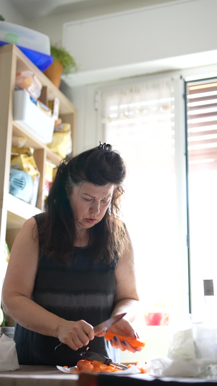mujer cortando zanahorias en la cocina